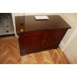 A mahogany two door cabinet the moulded top above a pair of panelled doors internally the cabinet