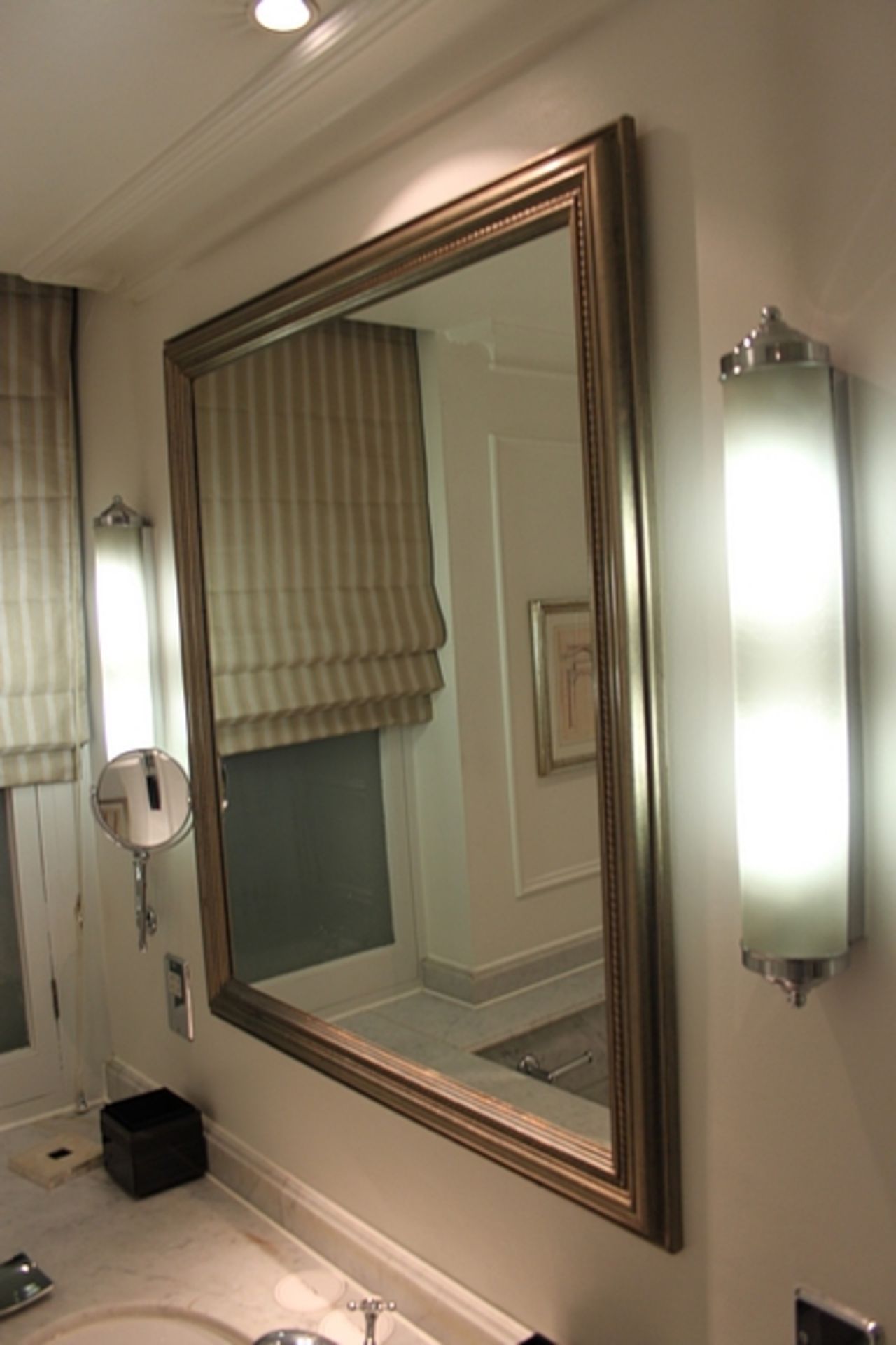A large contemporary wall mirror in a silver wood framed with its beautiful designs and unique