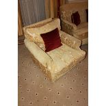 A traditional easy armchair upholstered in a gold broccade fabric mounted on solid legs 800mm x