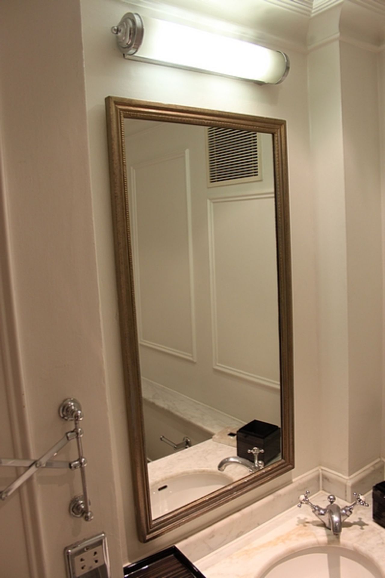 A large rectangular contemporary wall mirror in a silver wood framed with its beautiful designs and