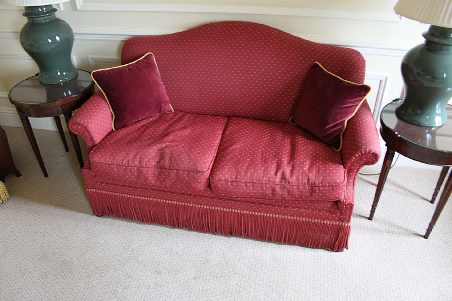 A two seater sofa upholstered in red fabric with repeating red gold dot pattern 1650mm x 800mm