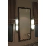 A large rectangular contemporary wall mirror in a silver wood framed with its beautiful designs and