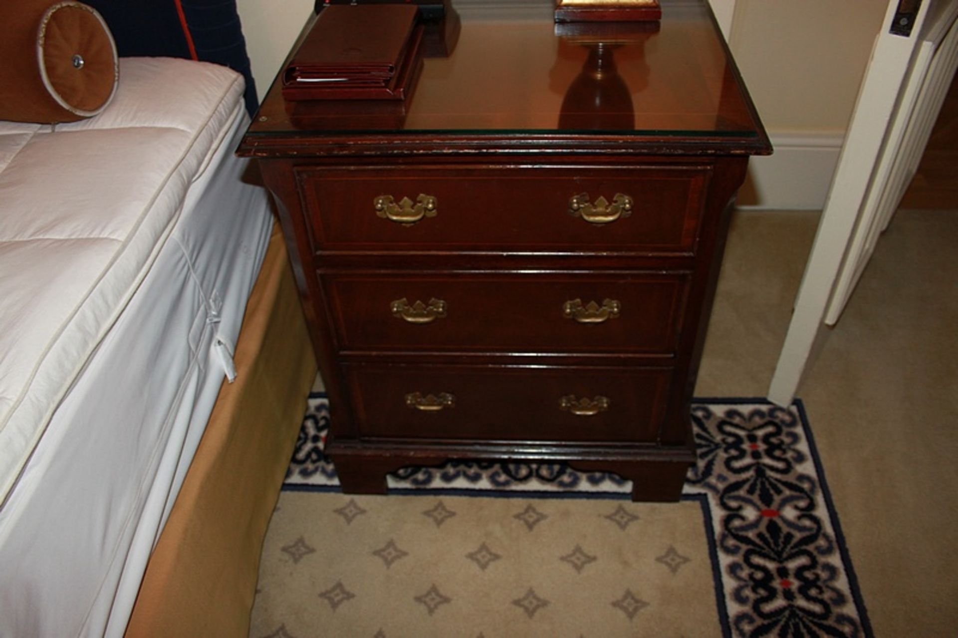 A pair of mahogany bedside cabinet chests in the Georgian style three drawers below, of dovetail