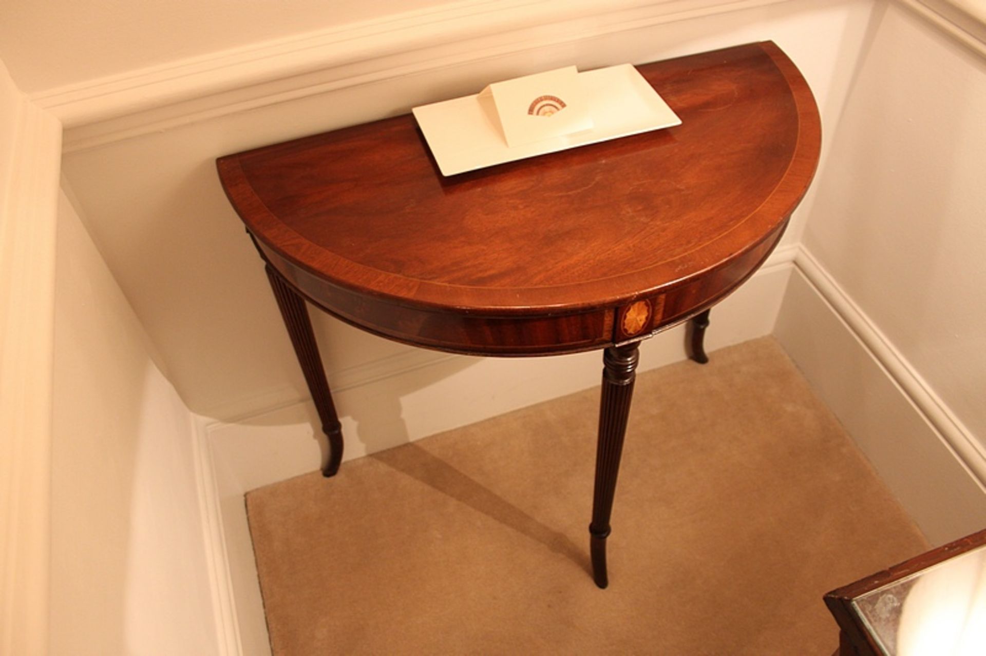 A Georgian style console table of demilune form with boxwood stringing mounted on four legs 950mm