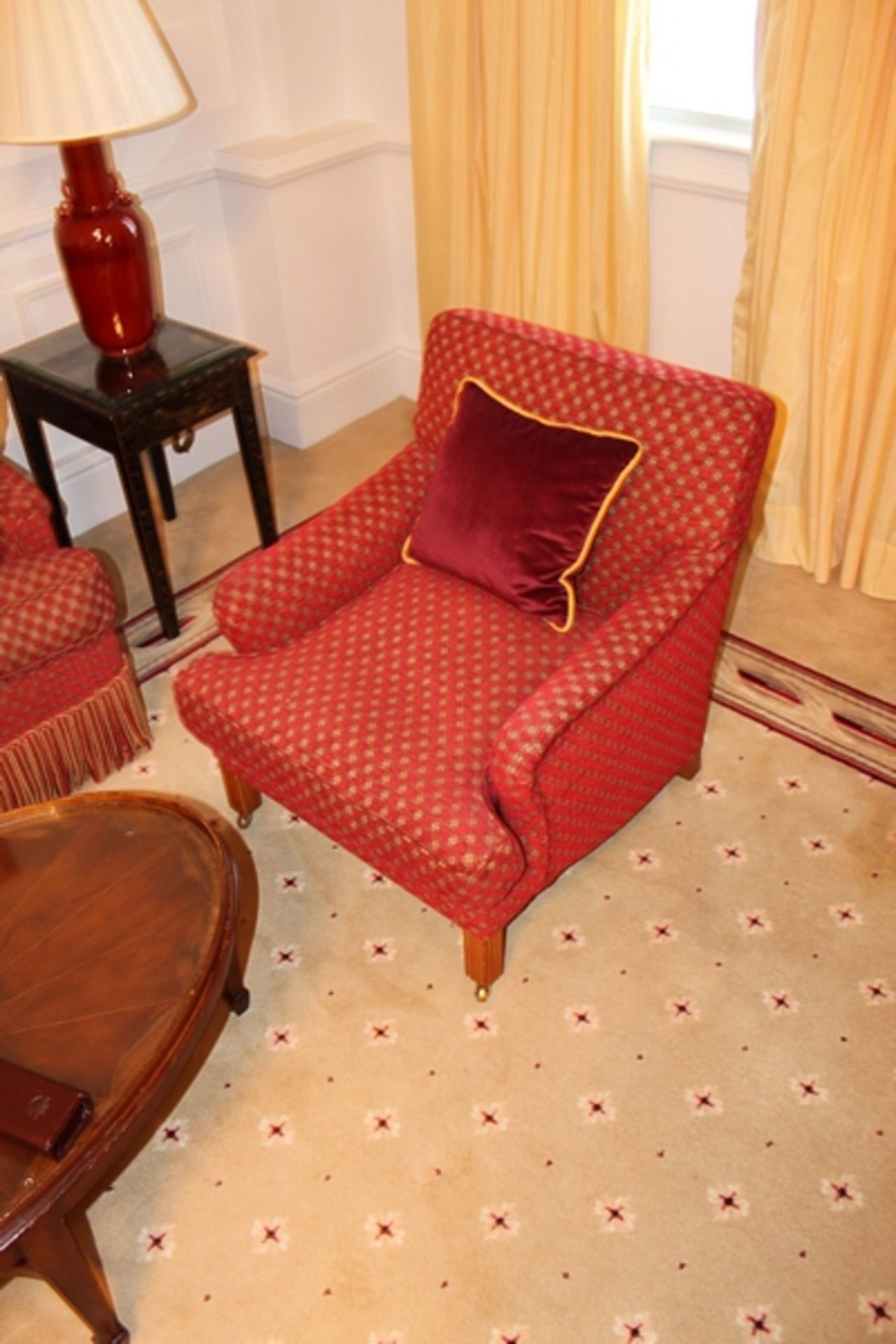 Armchair upholstered in red fabic with repeating red check pattern casters to front 700mm x 800mm