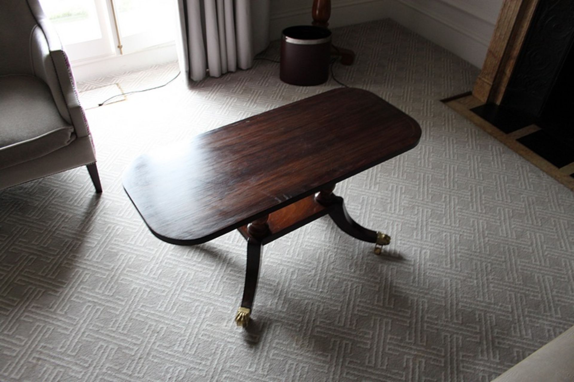 A Georgian style mahogany coffee table shaped supports stood on a platform base with four outswept