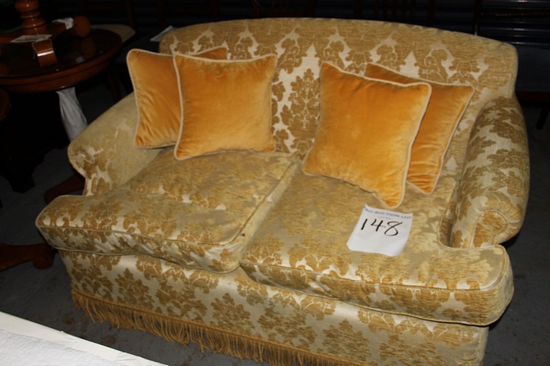 A two seater sofa upholstered in a gold broccade fabric casters to front 700 x 800mm