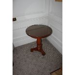 A pair light mahogany circular top table on carved baluster column and raised on a tri-form base