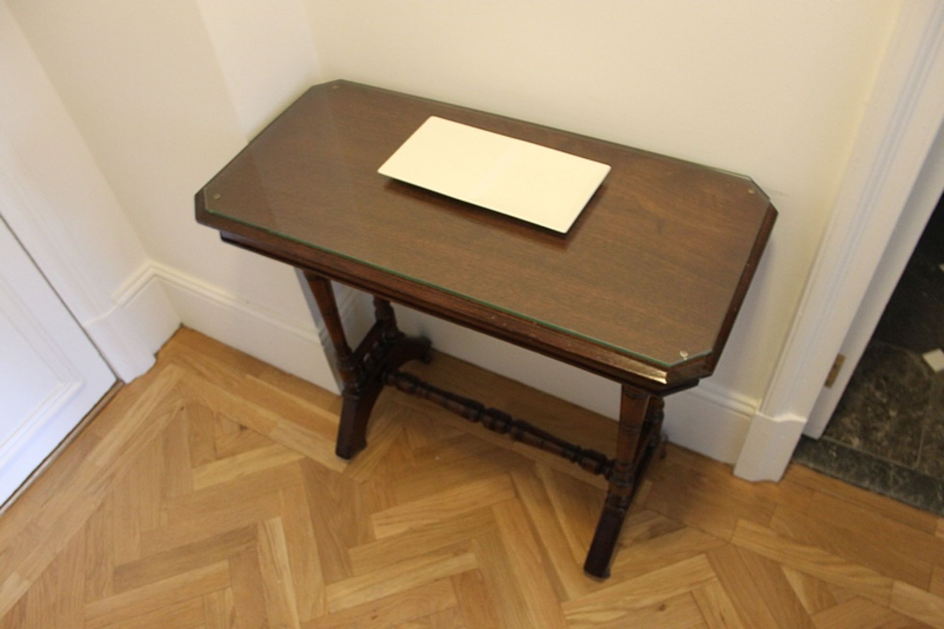 A mahogany occassional table with single turned stretcer mounted on casters 800mm x 350mm