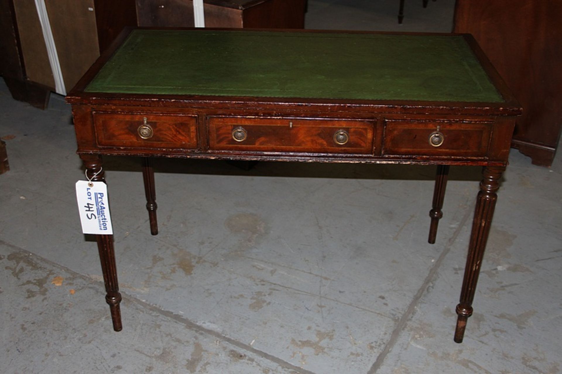 A Georgian style mahogany three drawer writing desk the top with tooled leather inlay mounted on