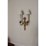 A brass twin arm wall sconce