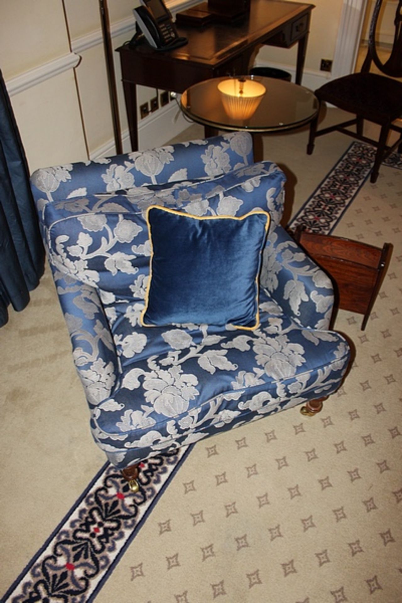 A traditional easy armchair upholstered in a blue broccade fabric casters to front 700 x 800mm