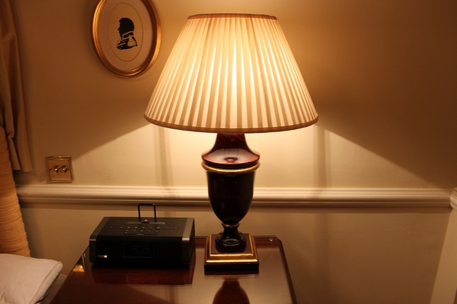 A large polished wood urn shape table lamp and shade