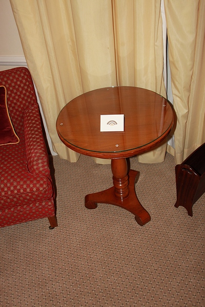 A light mahogany circular top table on carved baluster column and raised on a tri-form base with