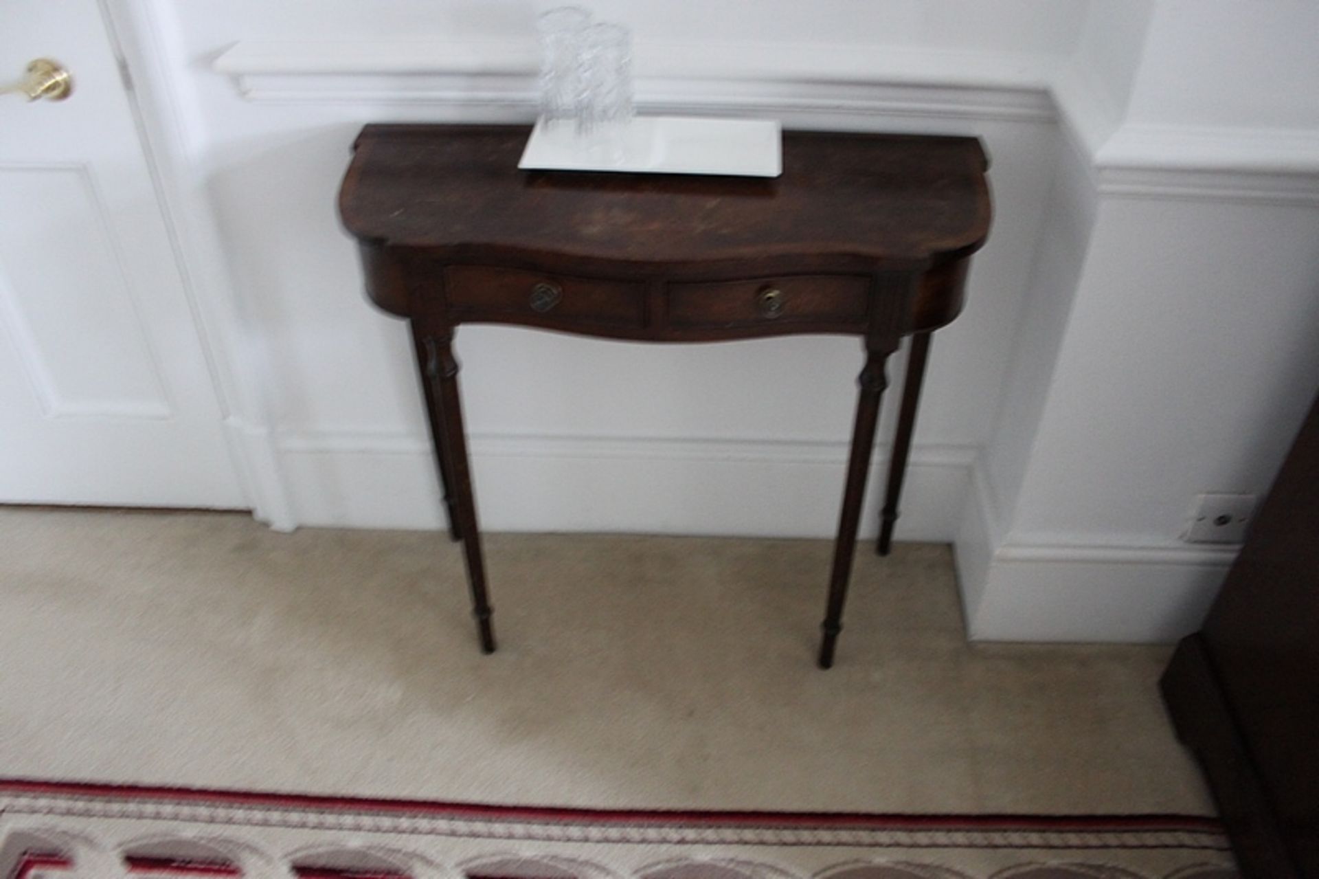 A mahogany demi lune console table mounted on turned legs 800mm x 330mm