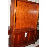 A mahogany bookcase open top mounted over two panelled doors 1200mm x 350mm x 2000mm