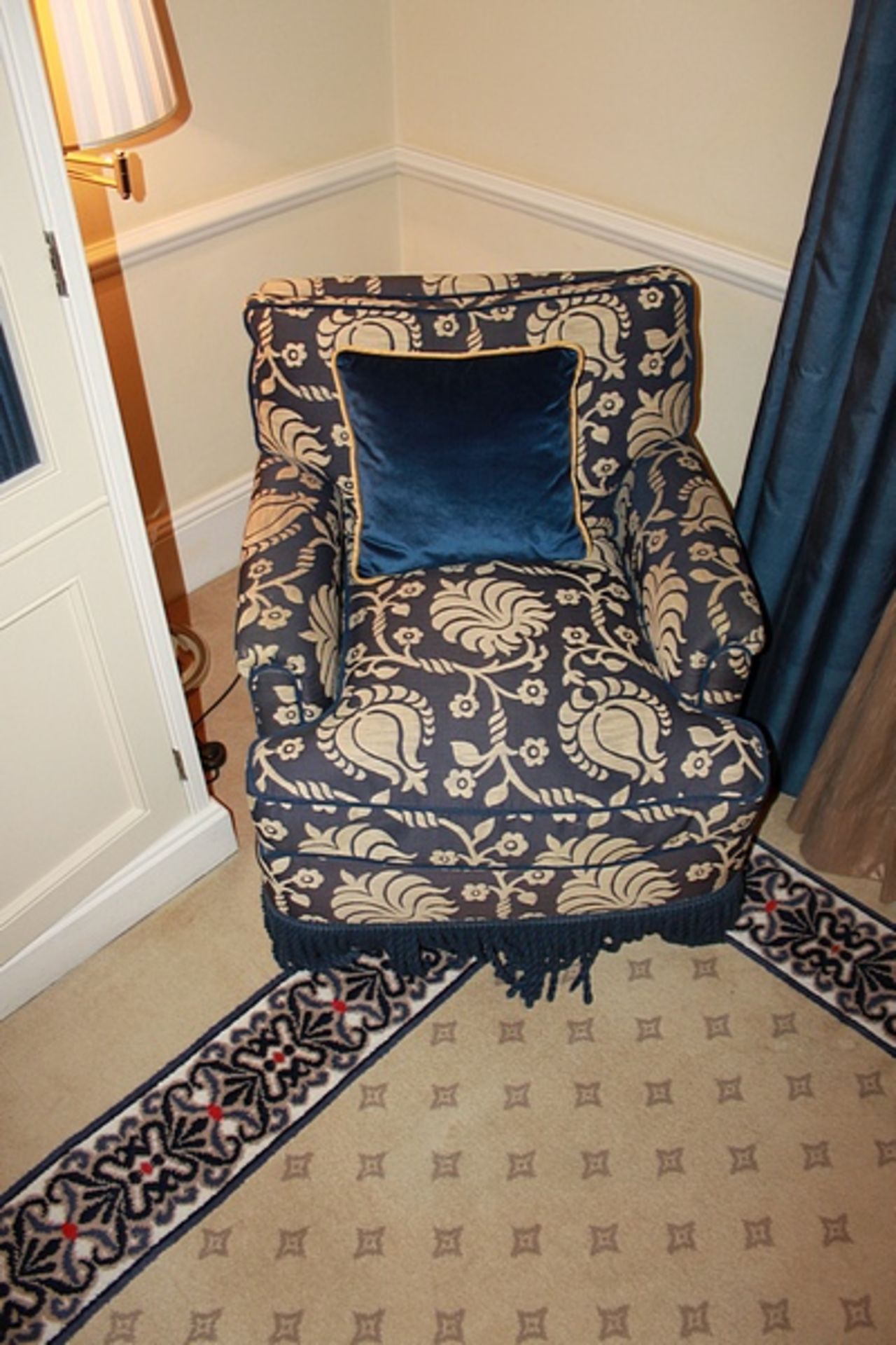 A pair of traditional easy armchair upholstered in a blue broccade fabric casters to front 700 x