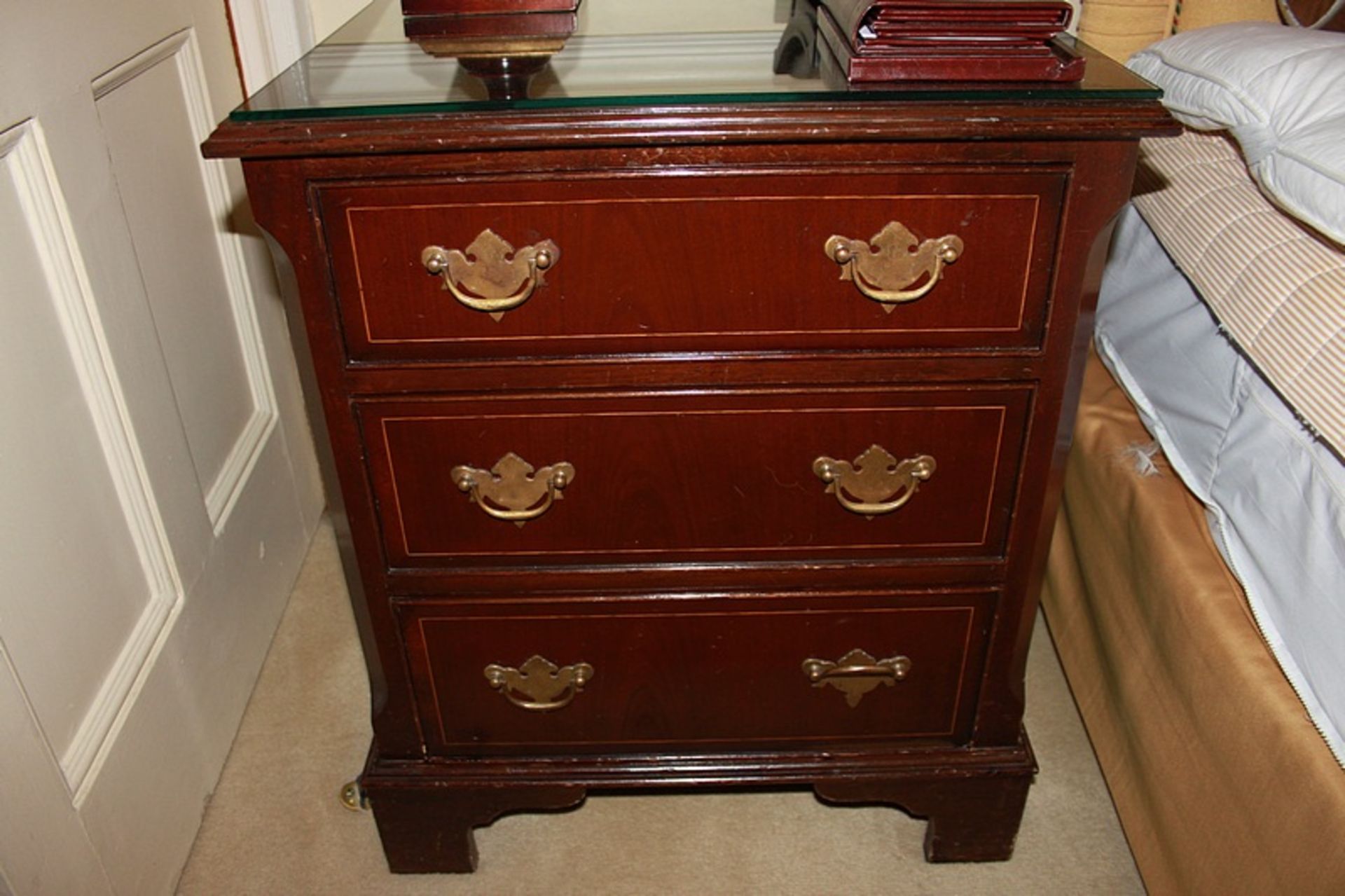 A pair of mahogany bedside cabinet chests in the Georgian style three drawers below, of dovetail