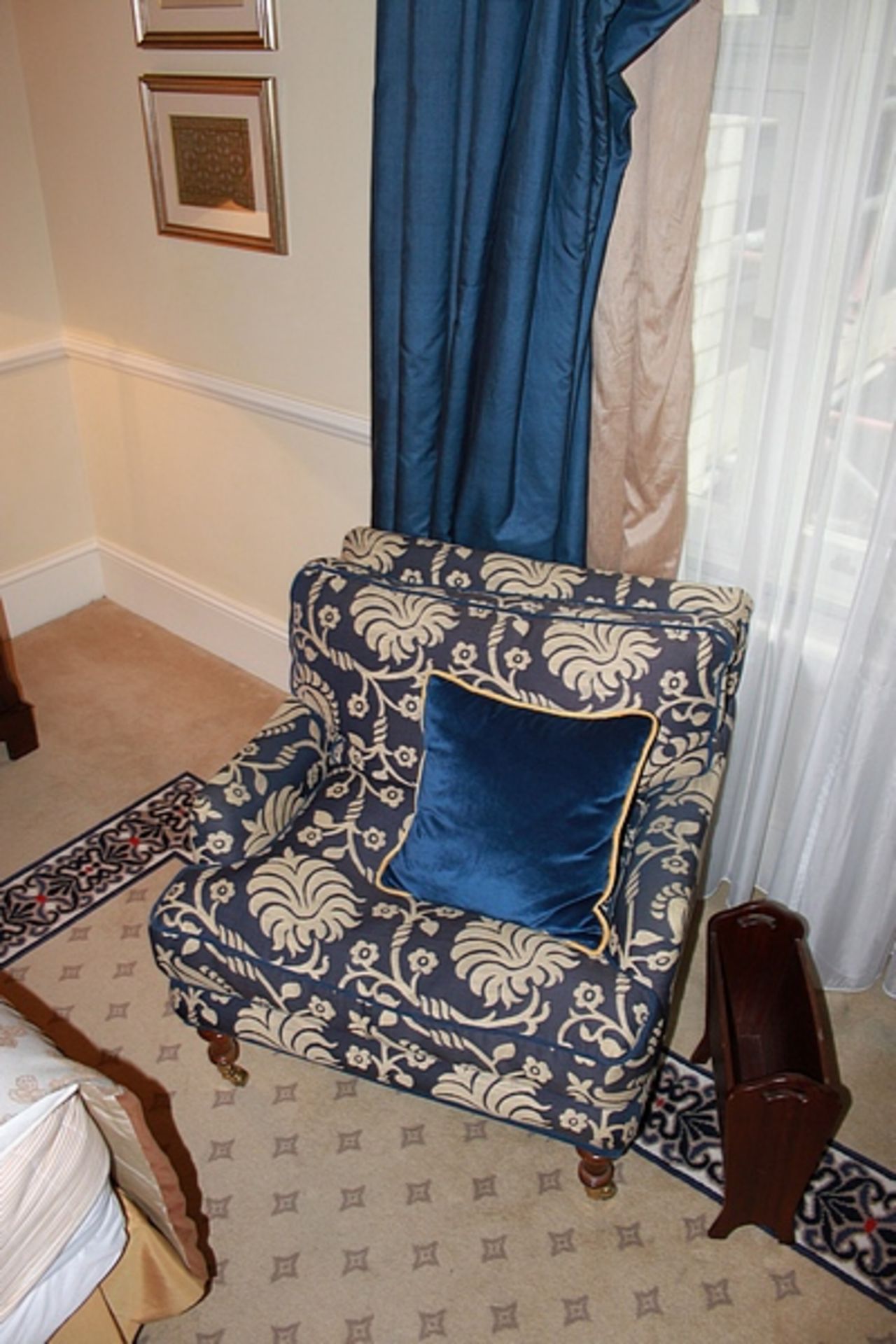 A traditional easy armchair upholstered in a blue broccade fabric casters to front 700 x 800mm