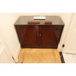 A mahogany two door cabinet the moulded top above a pair of panelled doors internally the cabinet