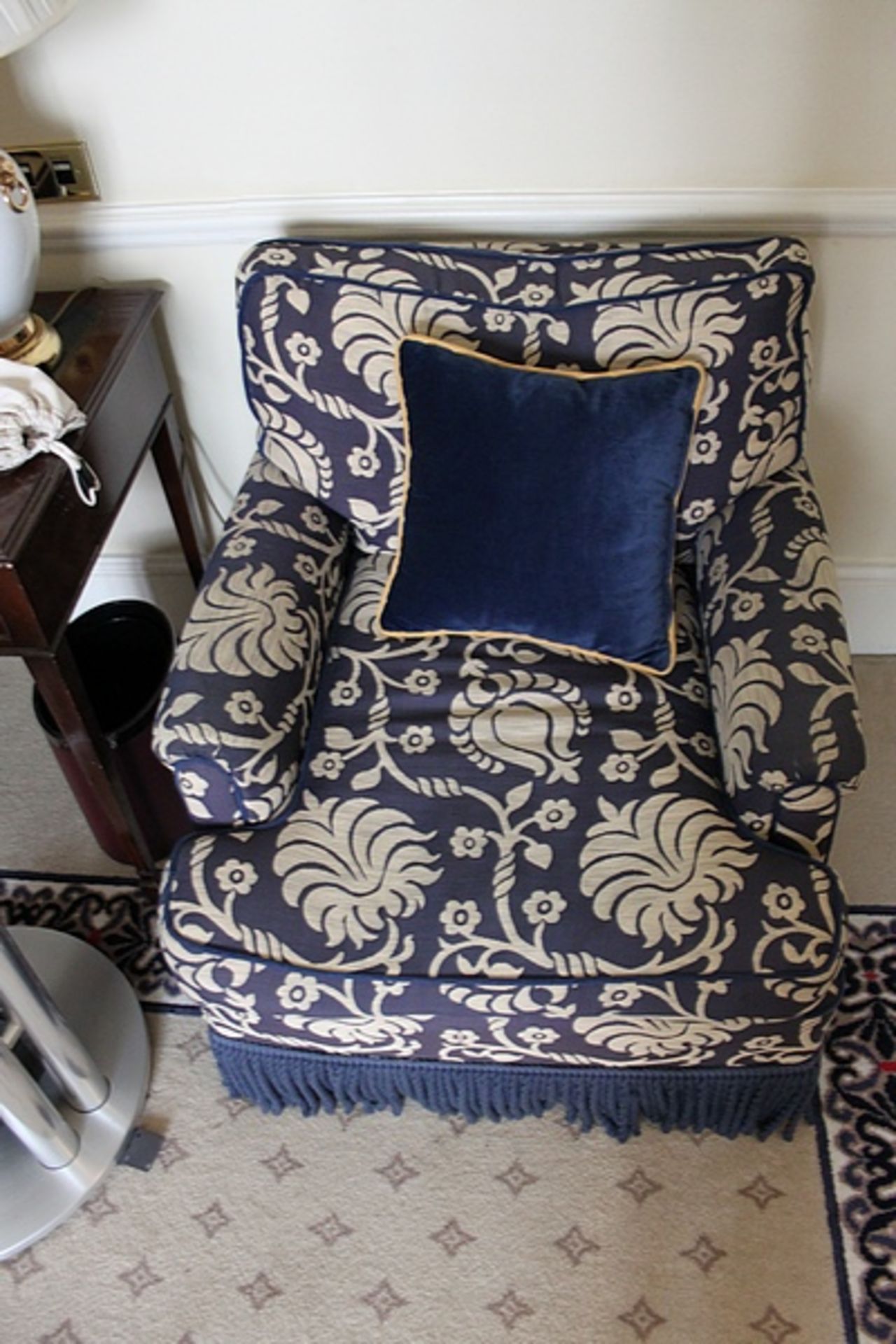 A traditional easy armchair upholstered in a blue broccade fabric frill base solid leg 700 x 800mm