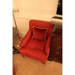 A pair of traditional easy armchairs upholstered in red with gold spot repeating pattern mounted