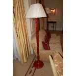 A red laquered floor standing lamp