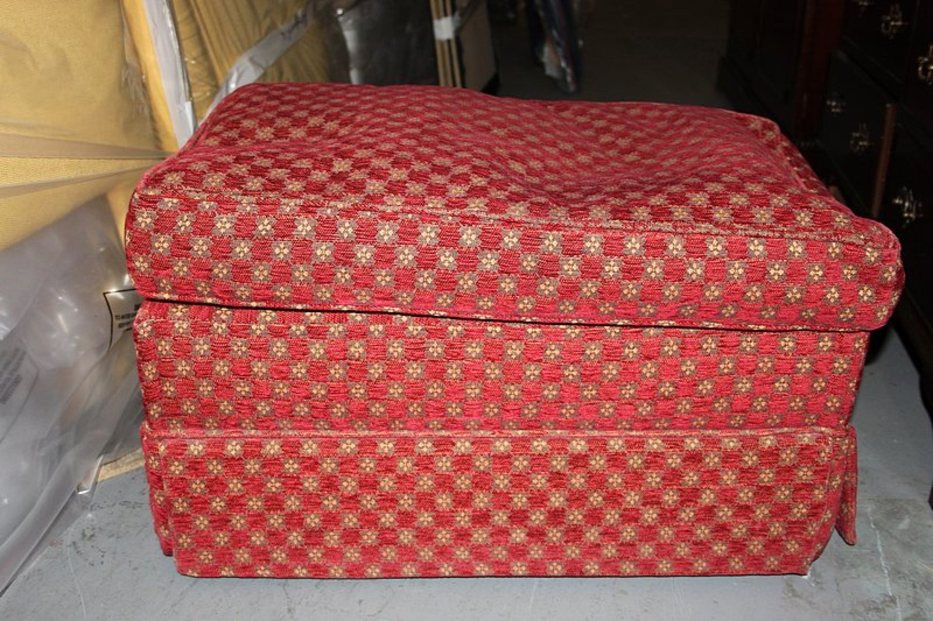 A upholstered red check pattern footstool