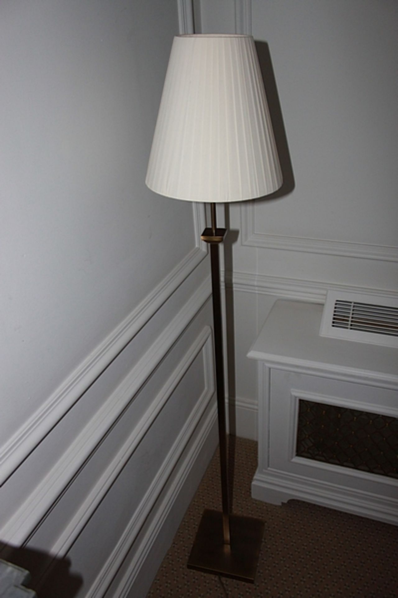 A contemporary floor standing lamp square base finished in antique bronze