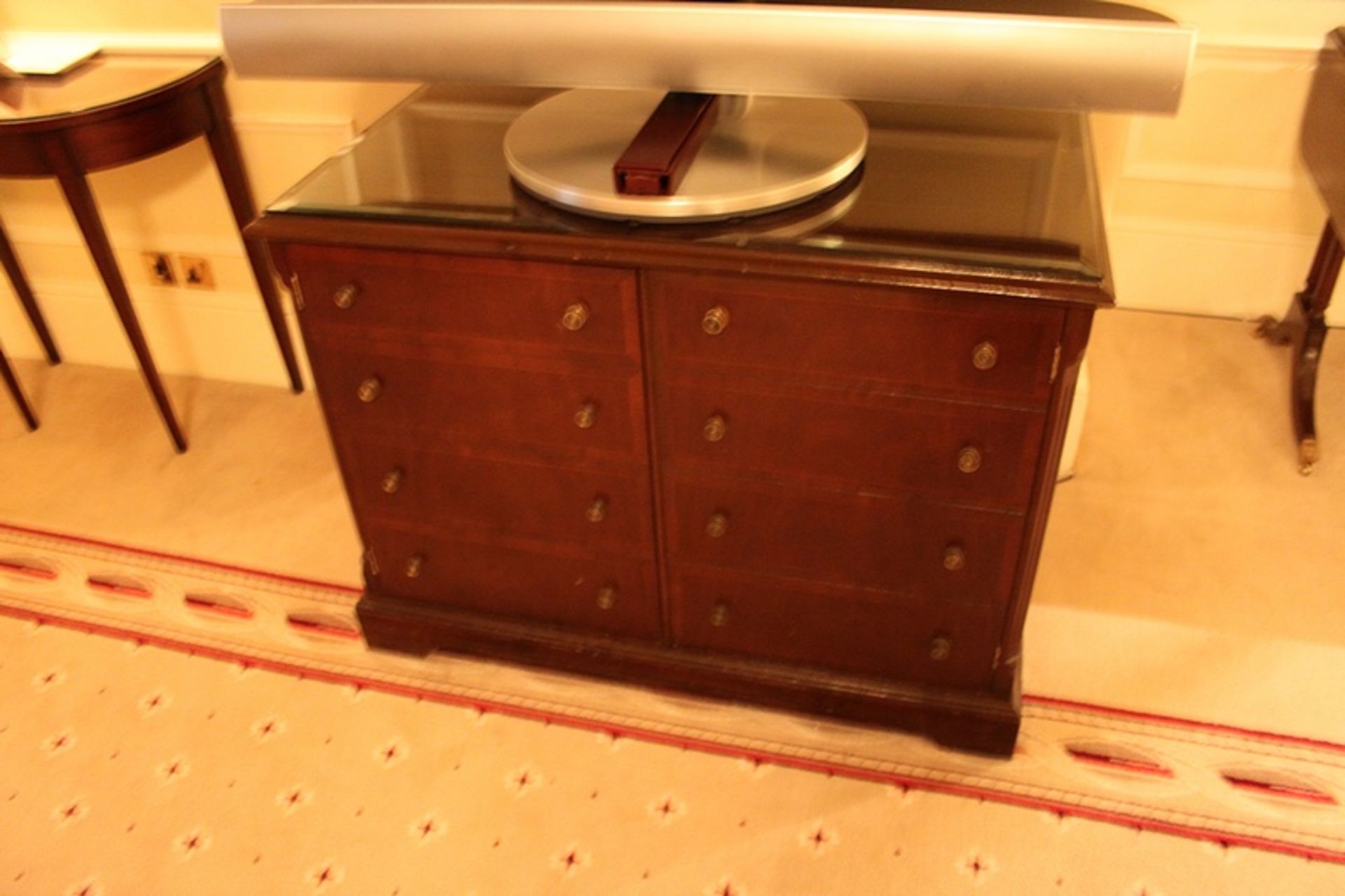 A mahogany moulded top two door side cabinet the door panel with a faux drawer frontage internally