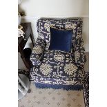 A blue upholstered brocade pattern footstool with frill base