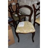 A mahogany side chair with a gold cream pad seat carved round back rest