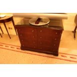 A mahogany two door cabinet the moulded top above a pair of half drawers and brushed slide tray with