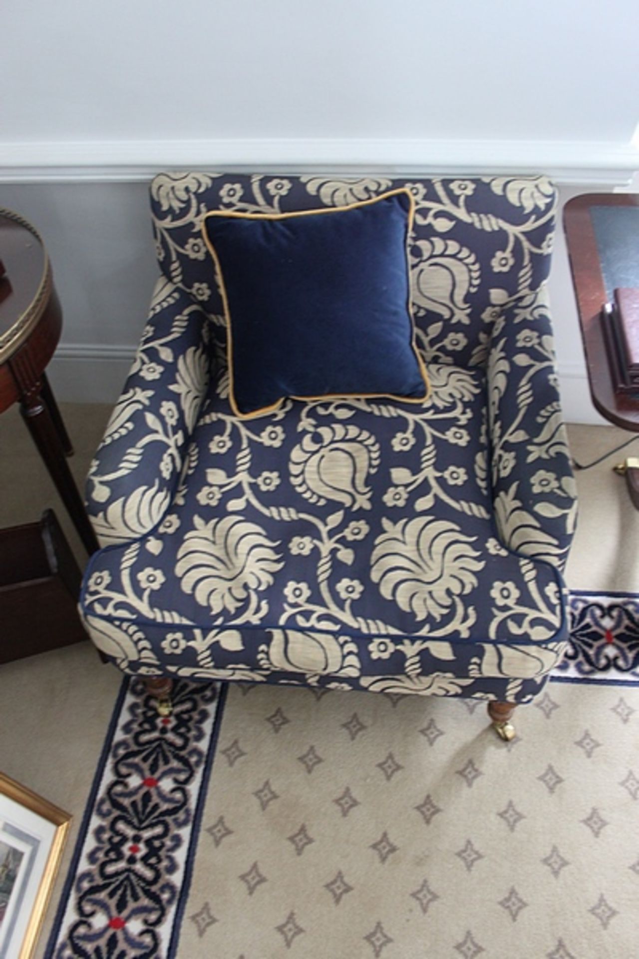 A pair of traditional easy armchair upholstered in a blue broccade fabric casters to front 700 x