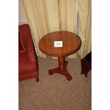 A light mahogany circular top table on carved baluster column and raised on a tri-form base with