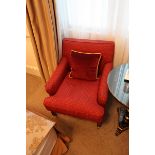 A traditional easy armchairs upholstered in red with gold spot repeating pattern mounted on solid