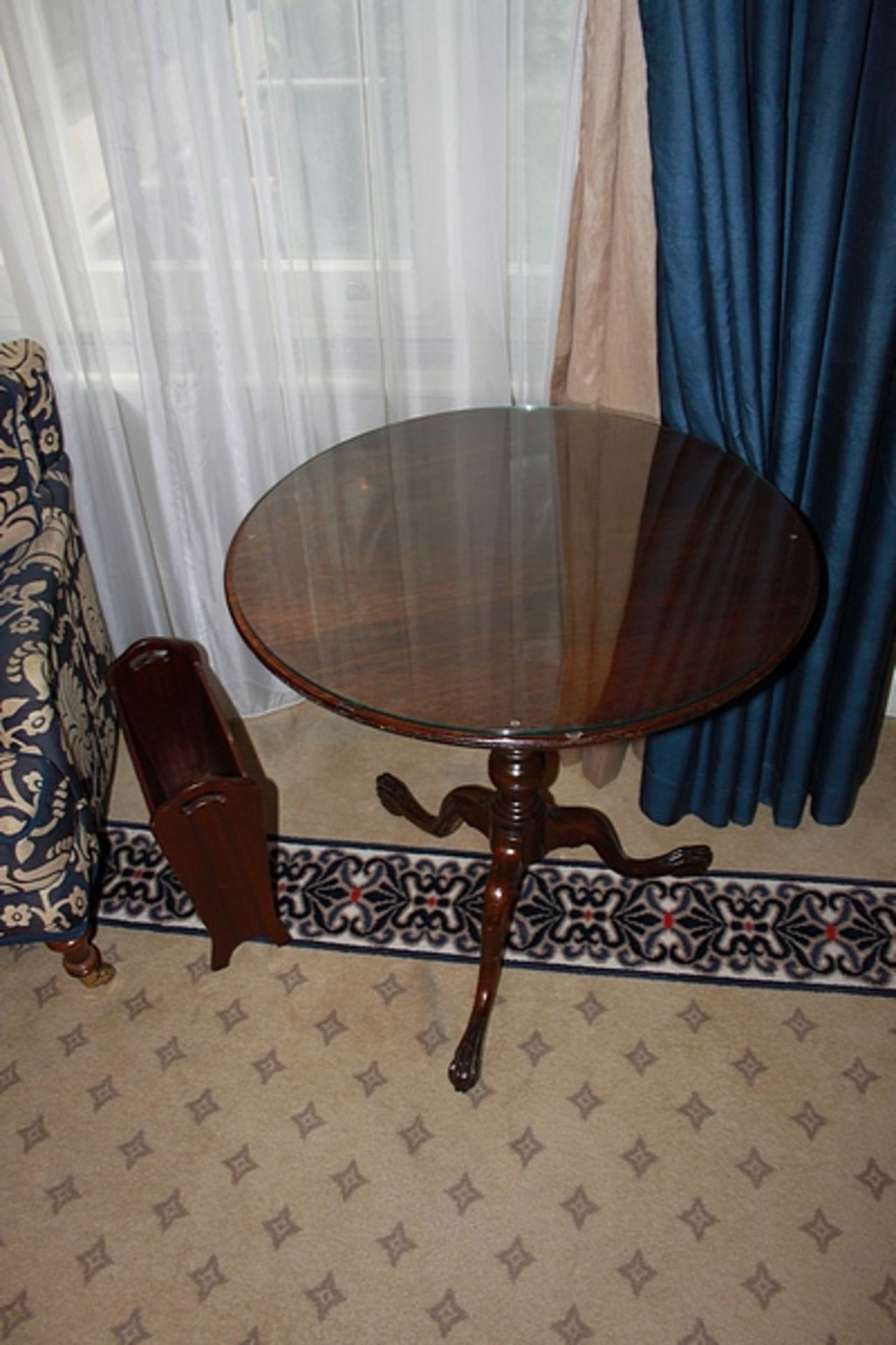 A pair of mahogany circular topside tables with a carved pron mounted on bow legs 600mm diameter