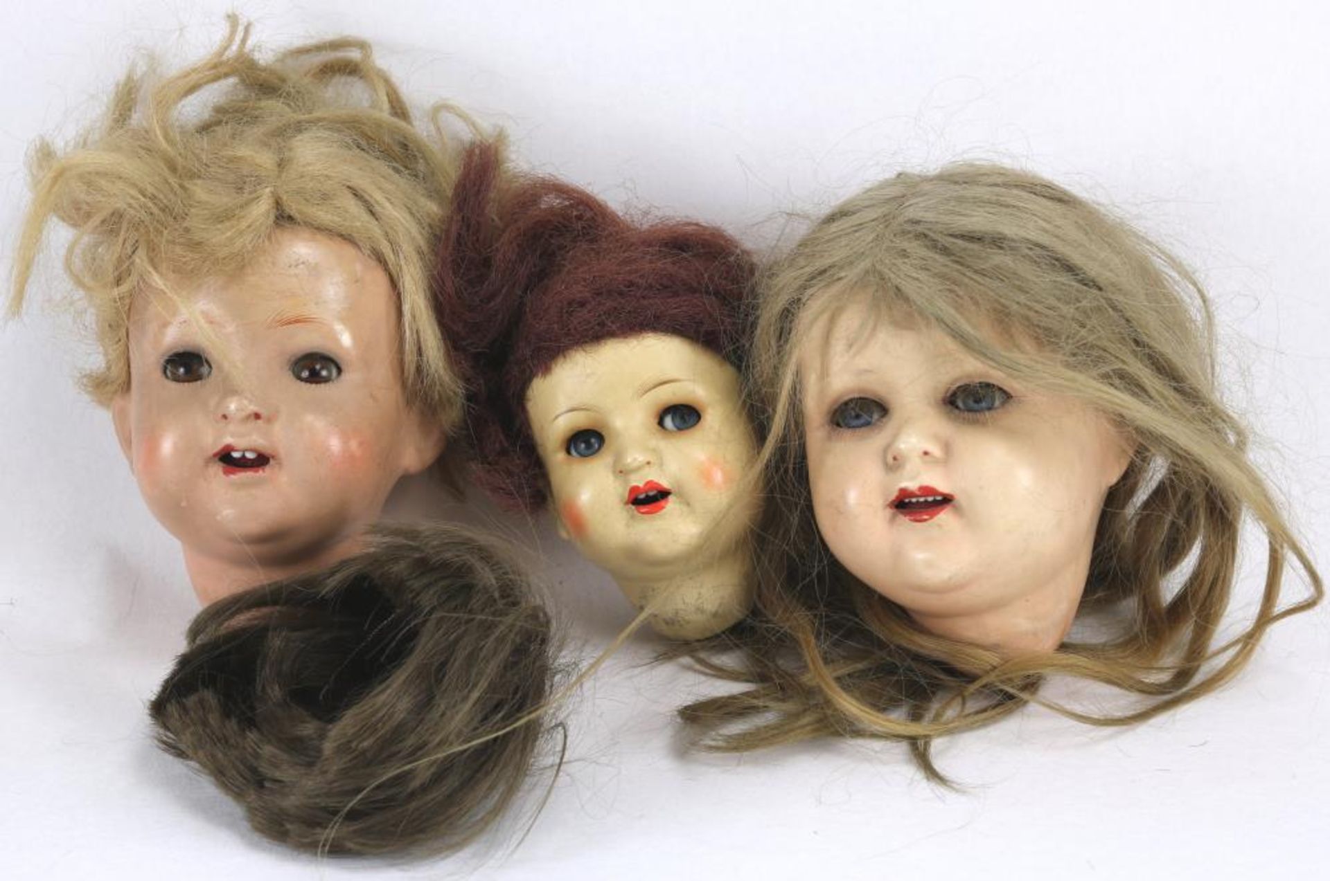 Drei Puppenköpfe. Diverse Ausführungen und Größen. Meist gemarkt. Größe bis ca. 15 cm.