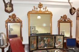 A pair of George III style parcel gilt mirrors, each horn and foliate carved crest and bevelled