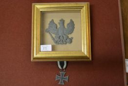 A Prussian military metal badge, probably from a Pickelhaube, framed; together with a German