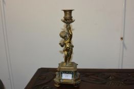 A 19th century French gilt-bronze and champleve enamel candlestick, modelled as a putto holding a