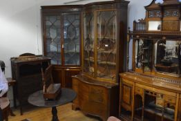 A George III style mahogany bookcase chest, the bookcase of serpentine form with a pair of