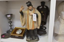 A 19th century painted terracotta figure of a Catholic priest, his right hand raised in benediction,