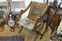 A late 19th century oak Glastonbury chair, of characteristic form, the back centred by a carved