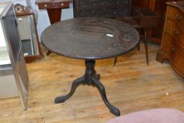 A George III tilt top tripod table, the circular top later carved (or replaced) with cartouches of