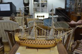 A wooden scale model of HMS Victory, mounted on a plain wooden plinth. Length 106cm, height 75cm