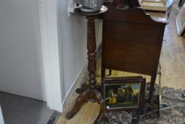 A 19th century mahogany torchere, the circular top on a leaf-carved turned column, raised on four