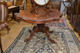 A mid-Victorian rosewood loo table, the shaped oval top with plain apron raised on a massive faceted