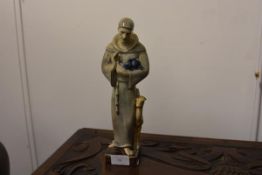 A glazed terracotta figure of Saint Francis, 20th century, modelled standing cradling birds in his