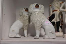 A pair of 19th century Staffordshire seated spaniels, each with shredded coat. 27cm